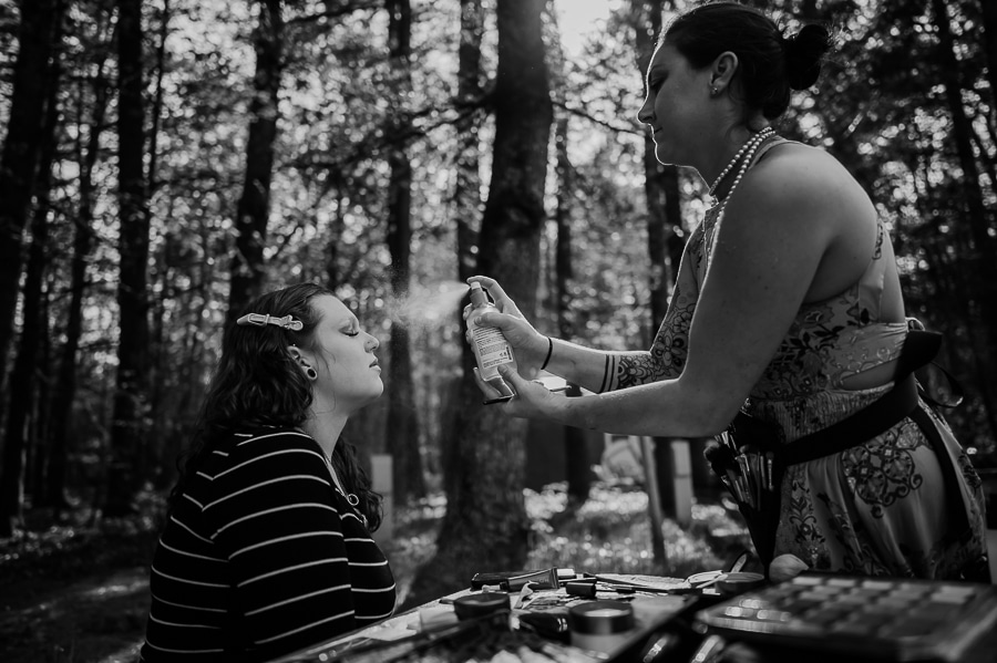 Black and white makeup artist spraying makeup setting spray