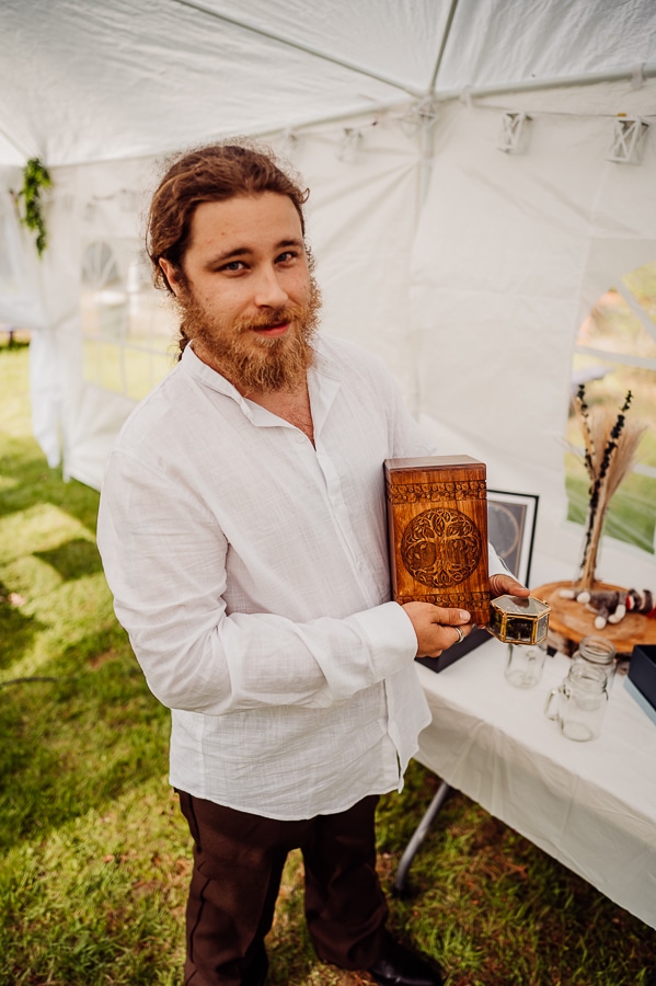 Groom holding sons urn before wedding