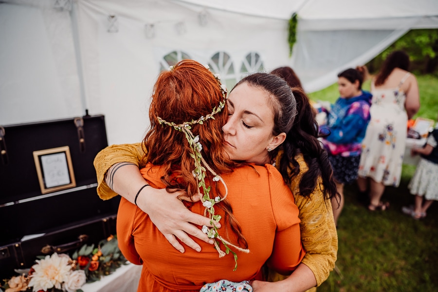 Woman in yellow hugging woman in orange dress