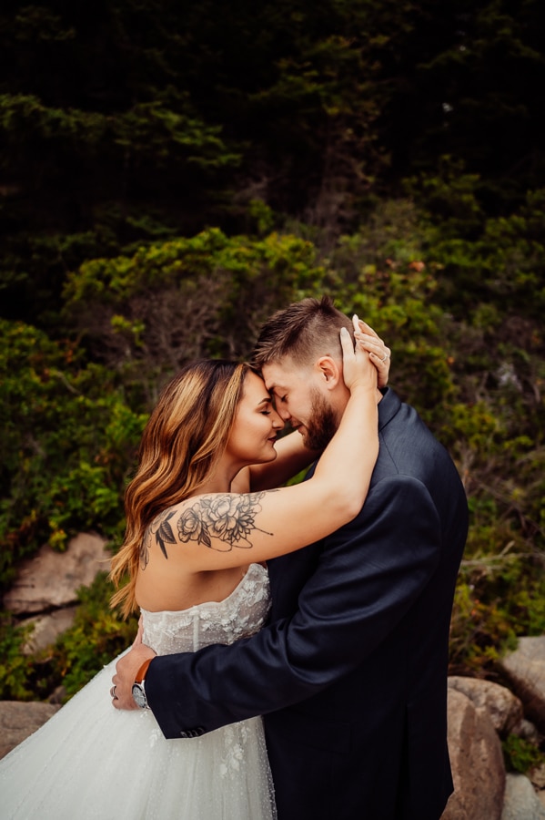 Bride with arm tattoo holding husbands head