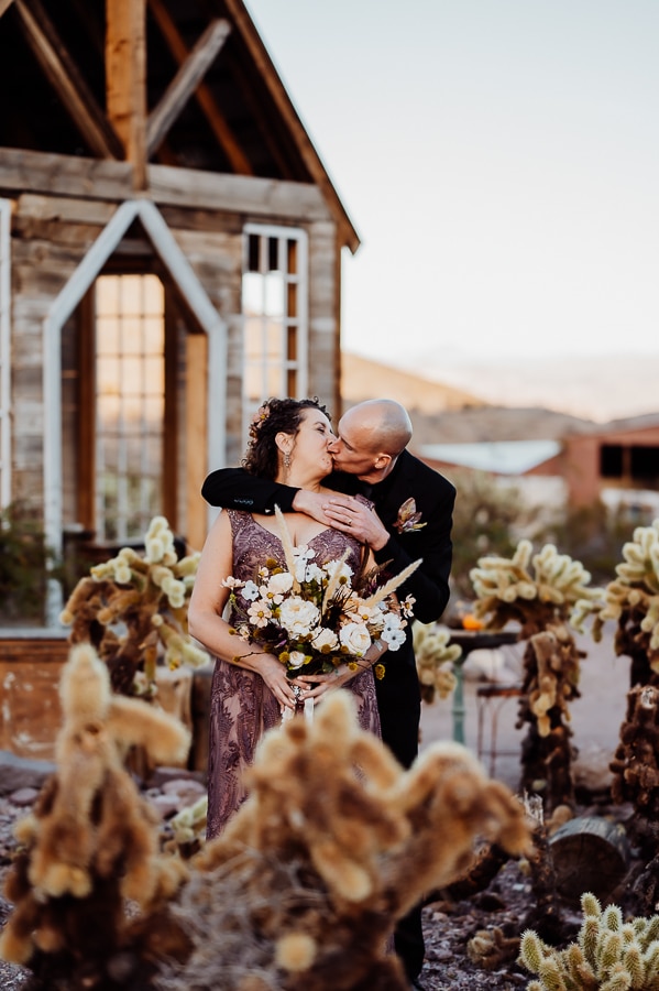 bride and groom behind cactus in nelson ghost town