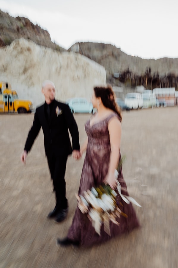 Bride and groom walking together in blurry photo at nelson ghost town