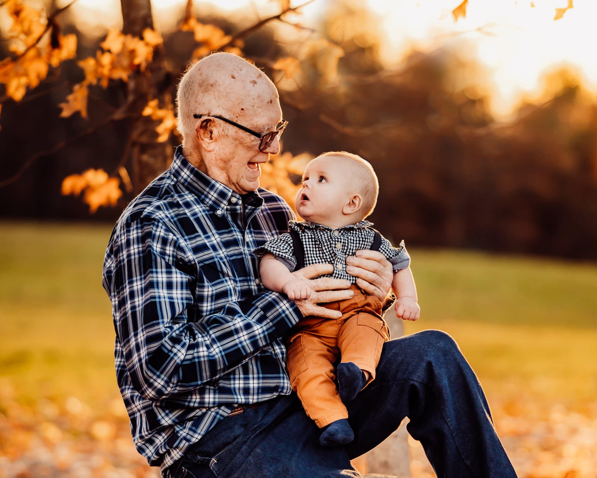 grandfather holding baby wearing plaid