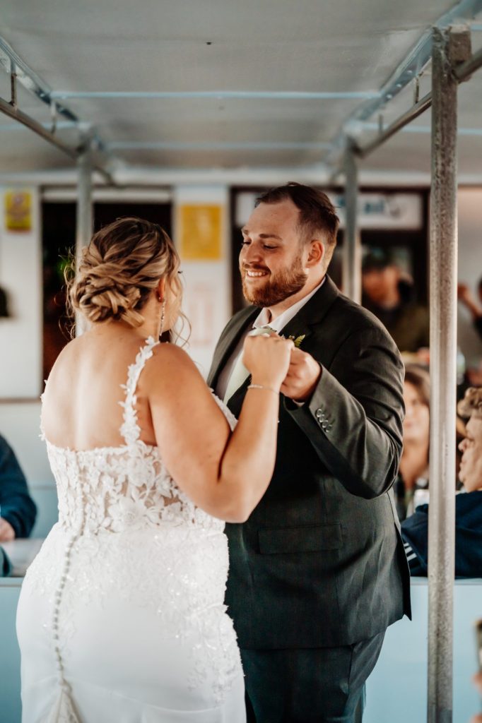 Bride and groom share their first dance aboard a Maine wedding charter boat Acadian Nature cruises surrounded by friends and family.