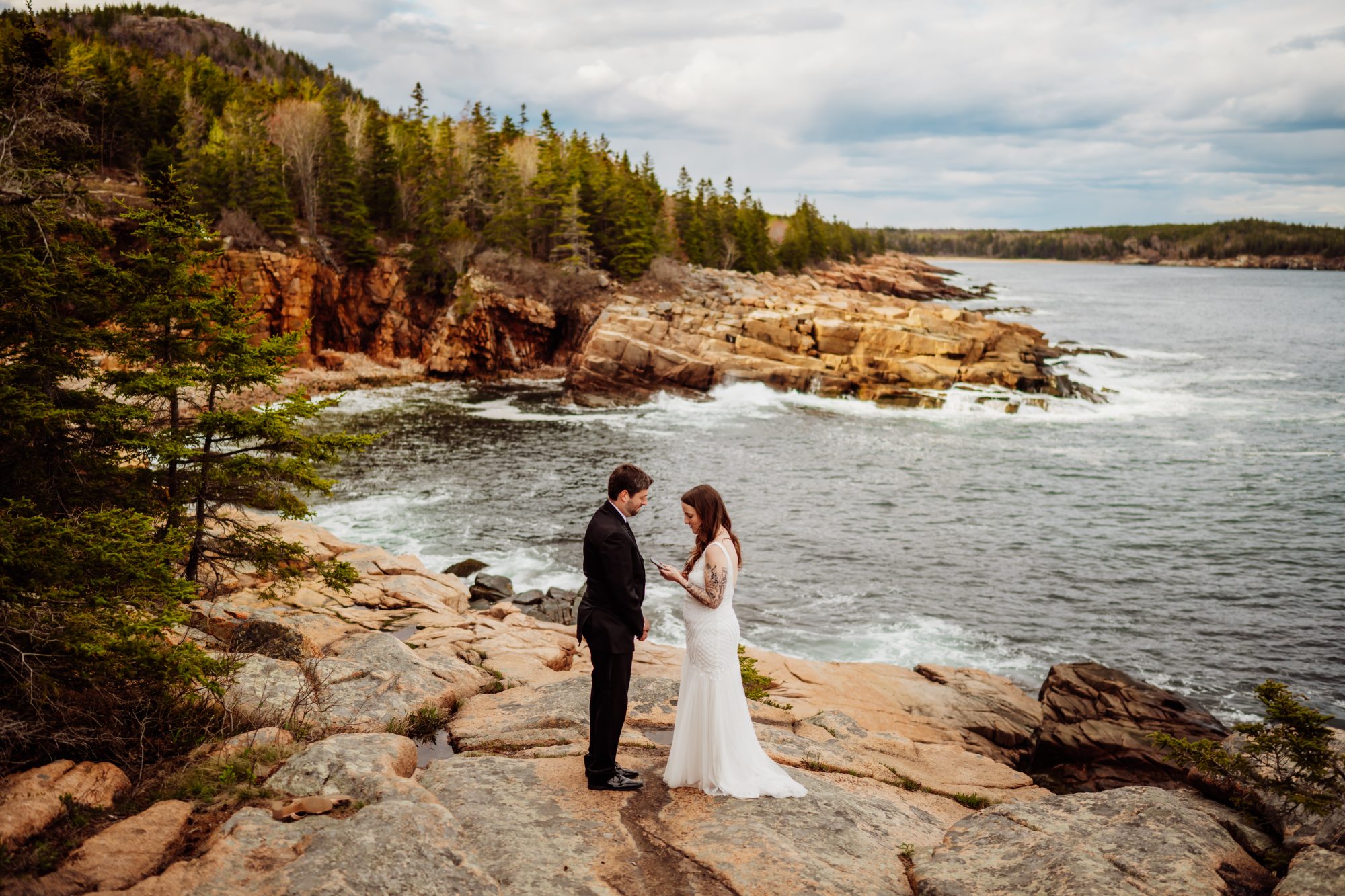 Intimate elopement ceremony on the rocky coastline near Otter Cliff with dramatic ocean views and crashing waves