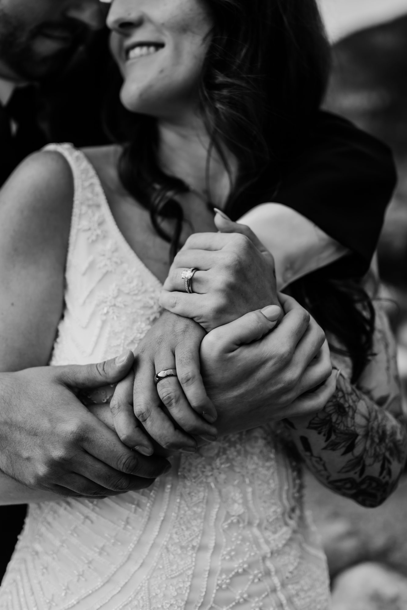 Black and white close-up of wedding rings and intertwined hands during an emotional Acadia National Park elopement