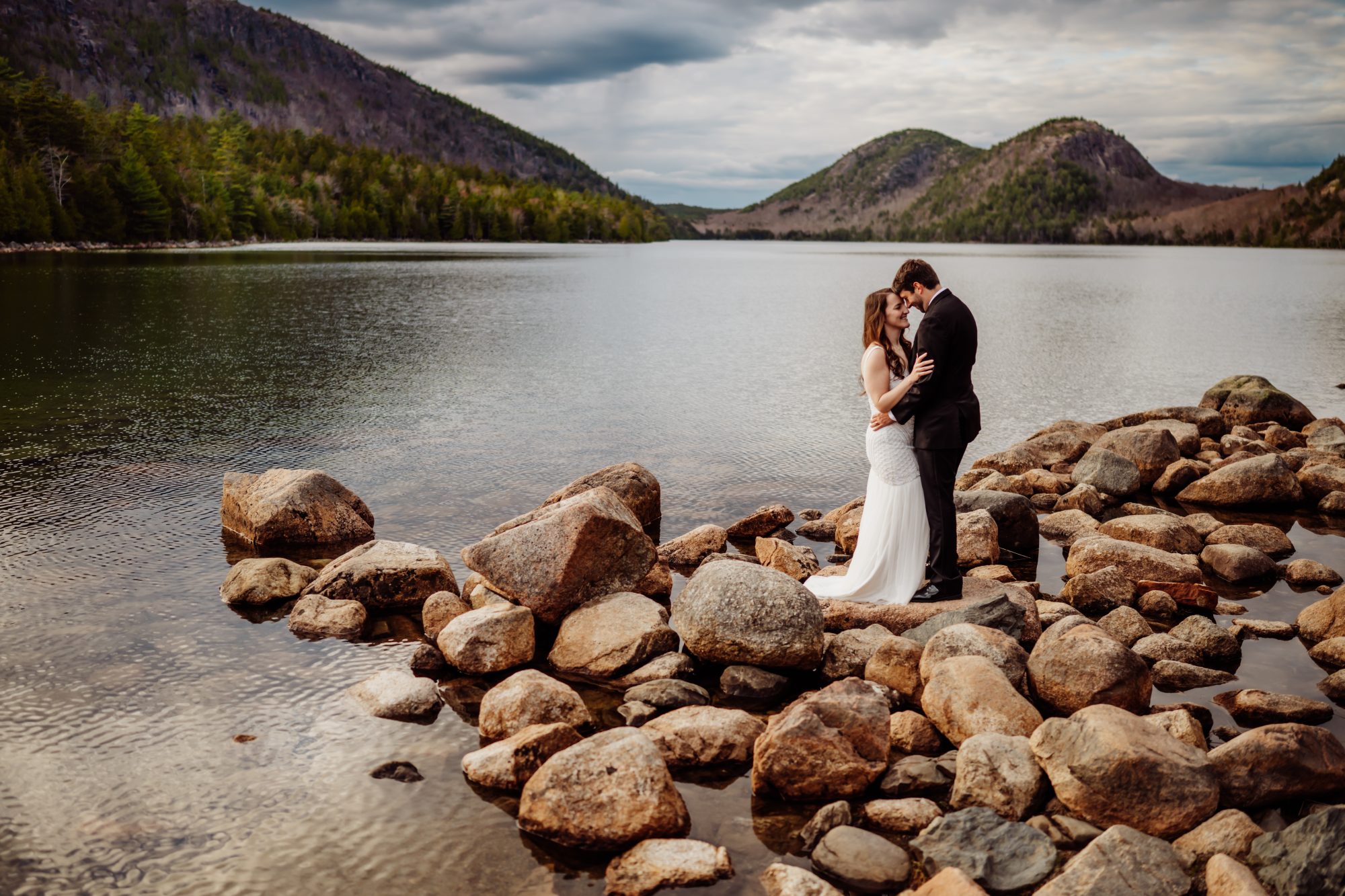 Intimate lakeside elopement portrait on the rocks at Jordan Pond with mountain views in Acadia National Park