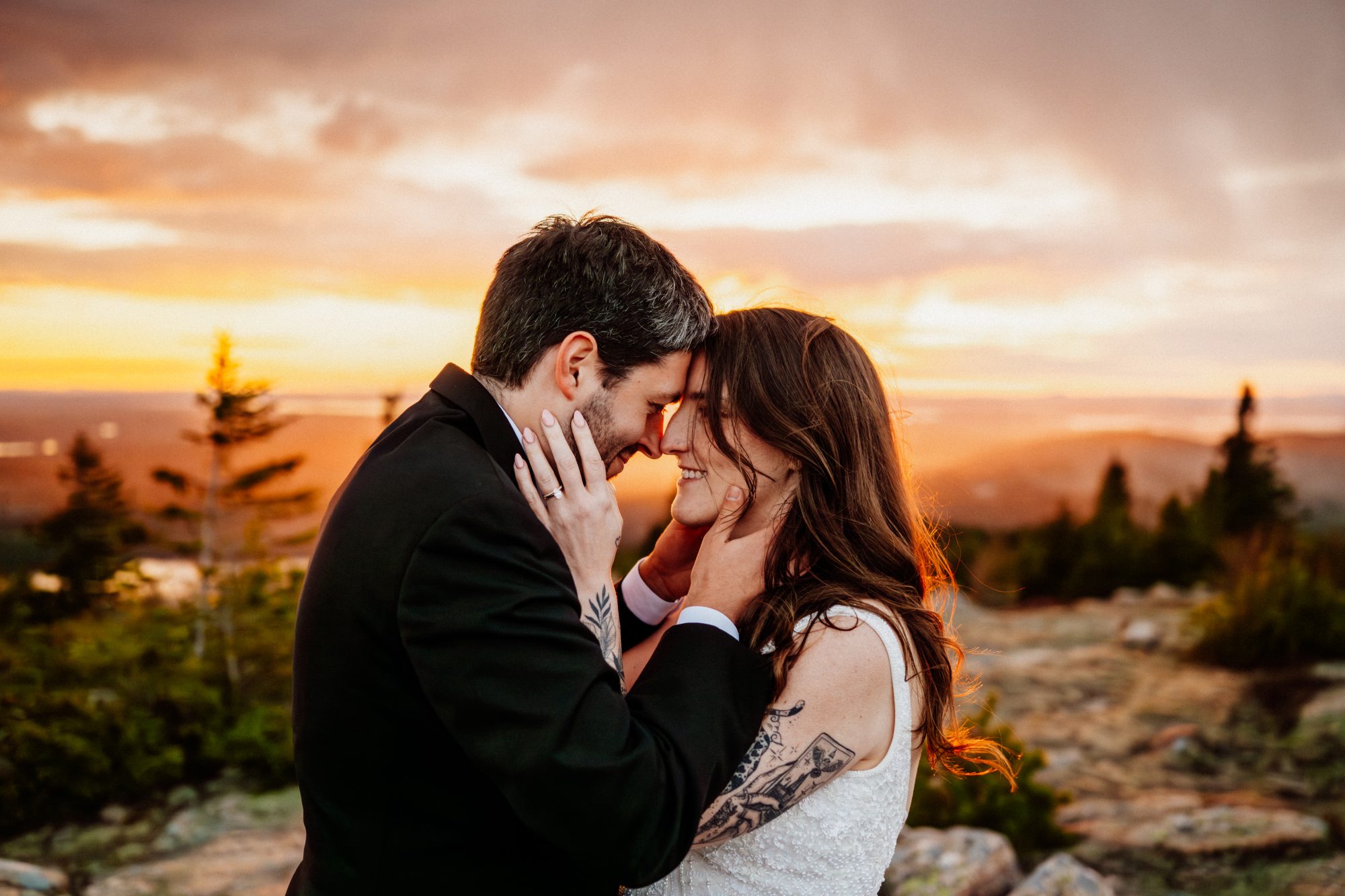 Emotional sunset elopement portrait with bride and groom touching foreheads in Acadia National Park